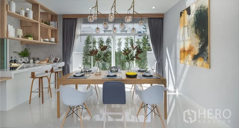 Detached House for sale in Lam Luk Ka, Pathum Thani - Dining area with six-seat wooden table, pendant lighting and a breakfast bar by full-height windows.
