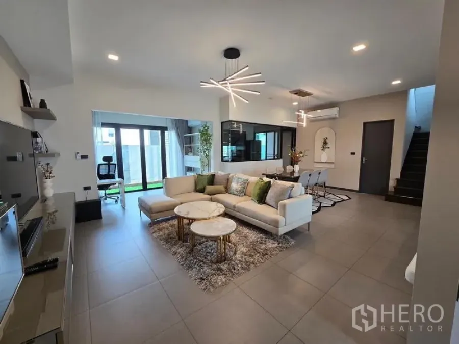 Townhouse for rent - Open living–dining zone with sectional sofa and geometric chandeliers