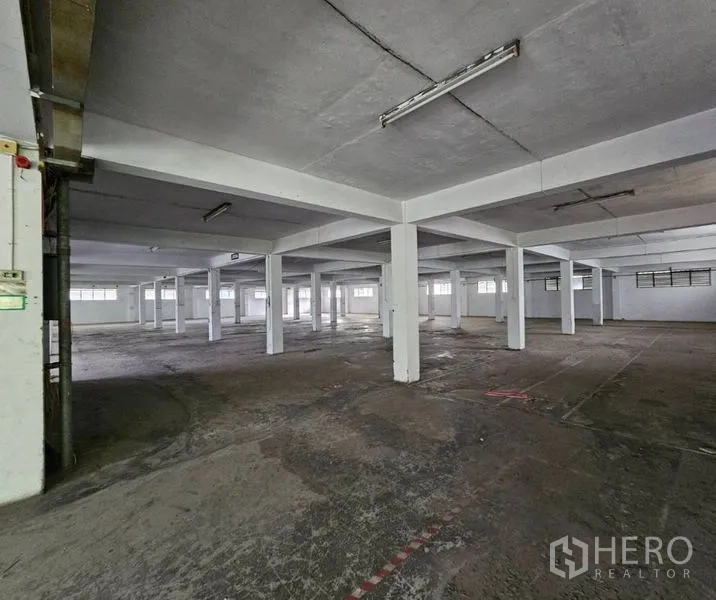 Factory for rent in Bang Kho Laem, Bangkok - Deep manufacturing hall with a grid of square concrete columns.