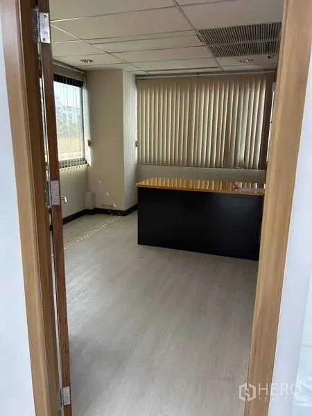 Office Space for rent in Khlong Toei, Bangkok - Private executive room with desk, window blinds and light wood flooring.