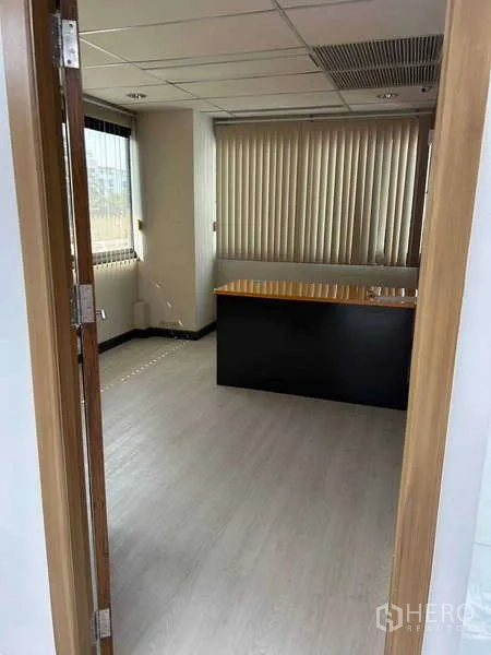 Office Space for rent in Khlong Toei, Bangkok - Private executive room with desk, window blinds and light wood flooring.