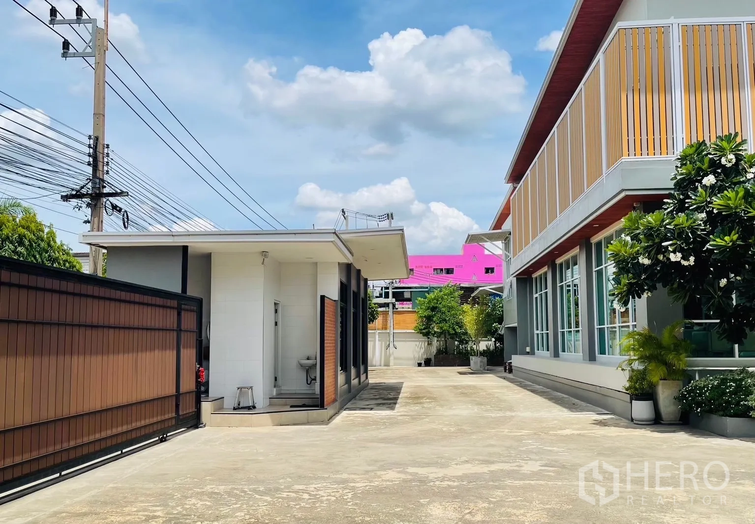 Factory for sale in Krathum Baen, Samut Sakhon - Internal driveway with guardhouse, sliding gate, and landscaped office facade.