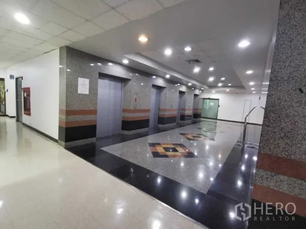 Office Space for rent in Watthana, Bangkok - Elevator lobby finished in granite with multiple lifts and recessed ceiling lights.