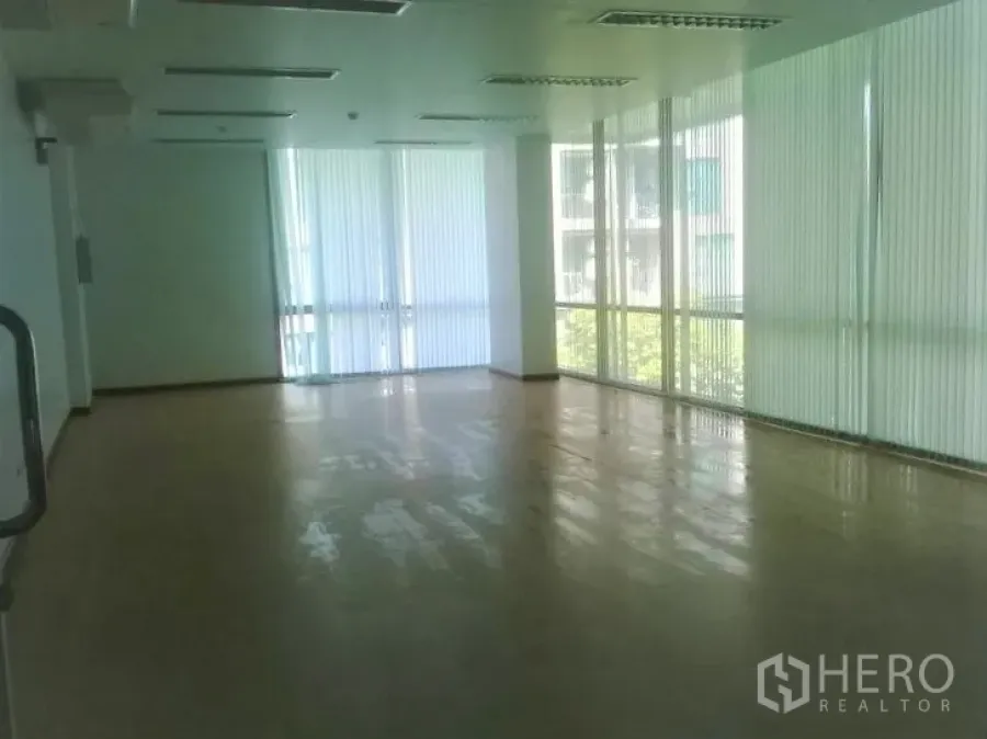 Office Space for rent in Phra Khanong, Bangkok - Sunlit empty office with corner floor-to-ceiling windows, vertical blinds, and fluorescent ceiling lights.