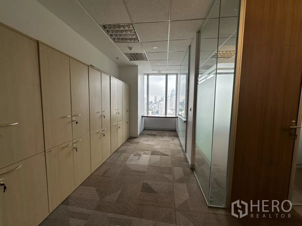 Office Space for rent in Watthana, Bangkok - Storage lockers and frosted glass partitions beside a window overlooking the city.