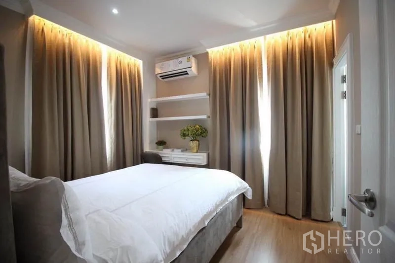 Detached House for rent or sale in Lat Phrao, Bangkok - Bright guest bedroom with double bed, shelving and wraparound curtains.