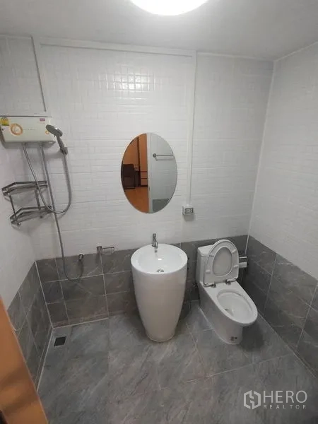 Detached House for rent in Prawet, Bangkok - Bathroom with pedestal sink, toilet and wall-mounted shower heater.