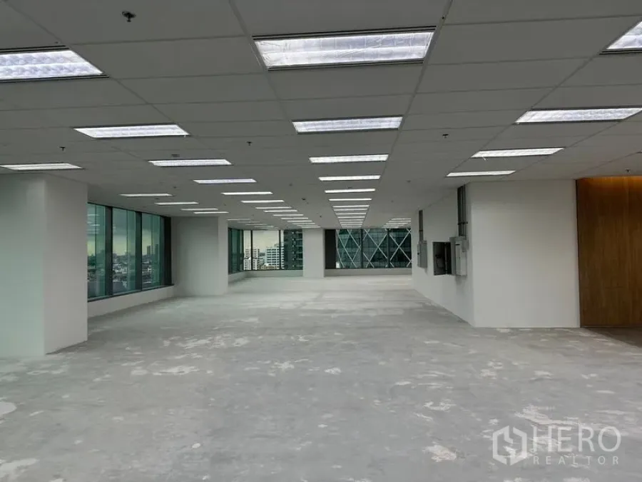 สำนักงาน ให้เช่าในRatchathewi, Bangkok - ชั้นสำนักงานกว้าง เพดานแขวนไฟเรียงแถว ผนังกระจกเต็มด้าน ใกล้โถงลิฟต์ผนังไม้