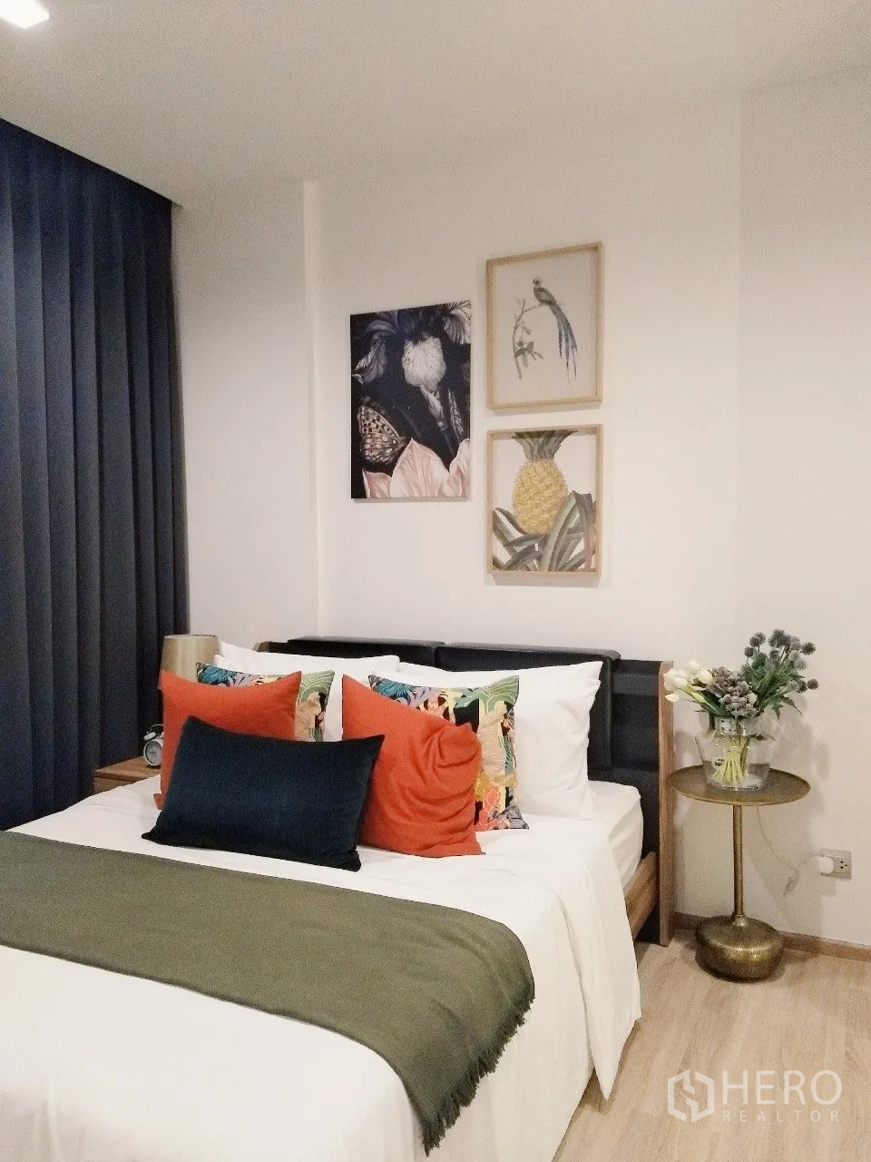 Condominium for rent in Watthana, Bangkok - Cozy bedroom with double bed, decorative pillows, artwork, and bedside table.