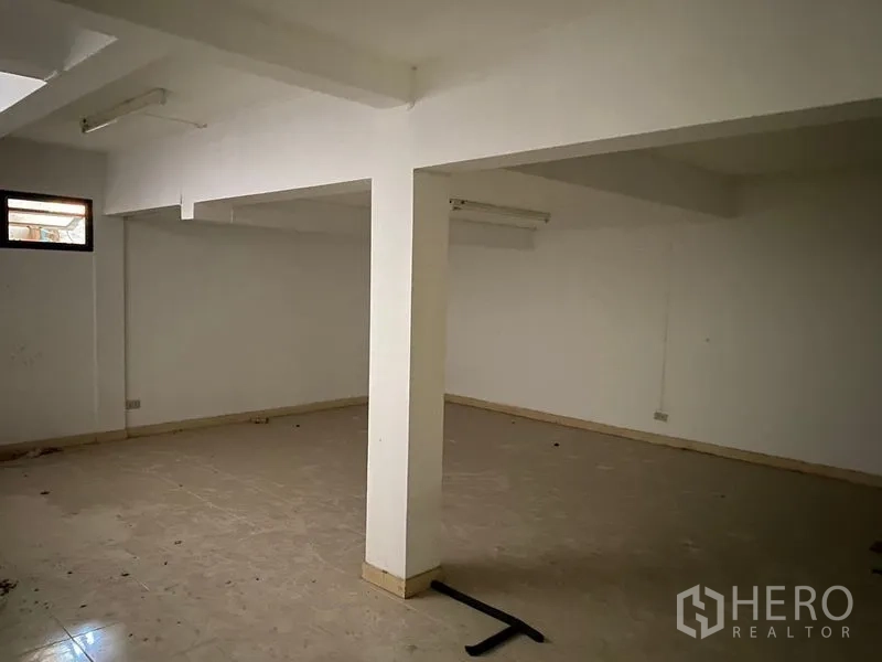 Home Office for rent in Pathum Wan, Bangkok - Spacious basement or multipurpose room with support columns and tile floor.