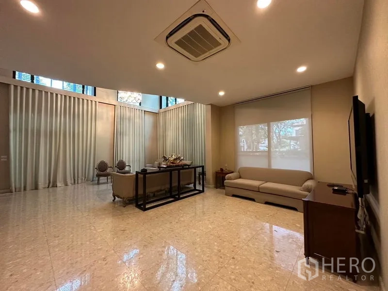独立式住宅 出租或出售在Khan Na Yao, Bangkok - 宽阔家庭厅，挑高天花、大理石地面与大屏电视。