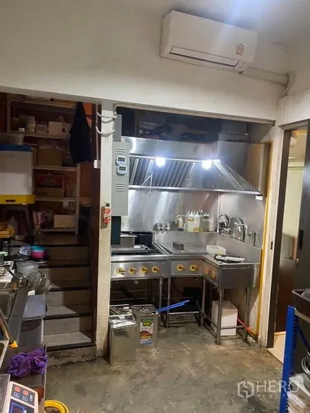 店屋 出租 - 紧凑型商用厨房，配不锈钢炉台、排烟罩和洗涤槽。