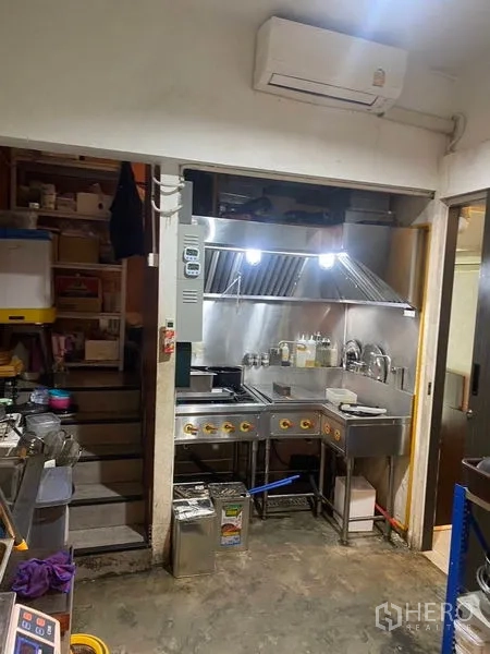 店屋 出租 - 紧凑型商用厨房，配不锈钢炉台、排烟罩和洗涤槽。