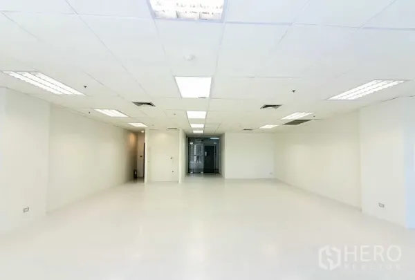 办公空间 出租在Khlong Toei, Bangkok - 开放式办公区面向玻璃入口门，白色墙面、嵌入式照明与中央空调出风口，干净现代。