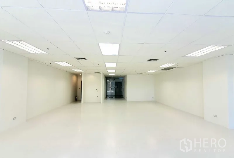 办公空间 出租在Khlong Toei, Bangkok - 开放式办公区面向玻璃入口门，白色墙面、嵌入式照明与中央空调出风口，干净现代。