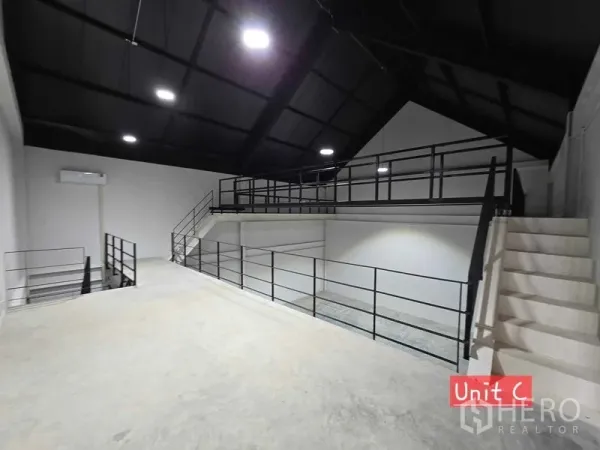 Home Office for rent in Chatuchak, Bangkok - Mezzanine level with metal railings and stairs under a high vaulted ceiling in an industrial-style space.