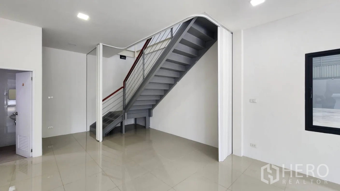 Factory for rent in Bang Bo, Samut Prakan - Metal staircase beside a restroom leading to the upper office level inside the factory.