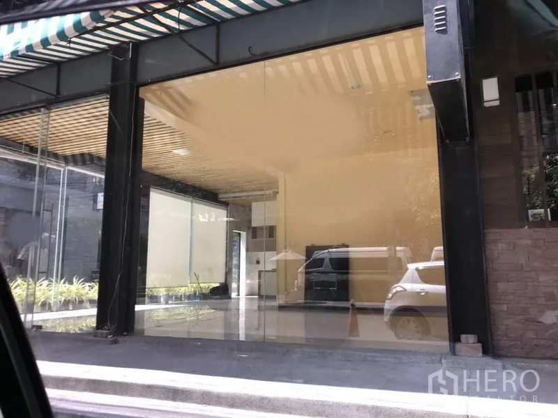 Retail Space for rent in Khlong Toei, Bangkok - Ground-floor retail unit with full-height glass facade, striped awning, and open-plan interior in Khlong Toei, Bangkok.