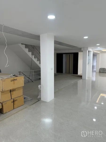 Office Space for rent or sale in Huai Khwang, Bangkok - Open-plan office showing stair, lift core and stacked packing boxes.