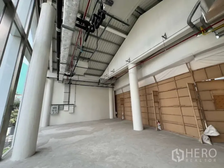 Retail Space for rent in Phaya Thai, Bangkok - High‑ceiling retail interior with exposed ducting, sprinkler pipes, structural columns and tall windows.
