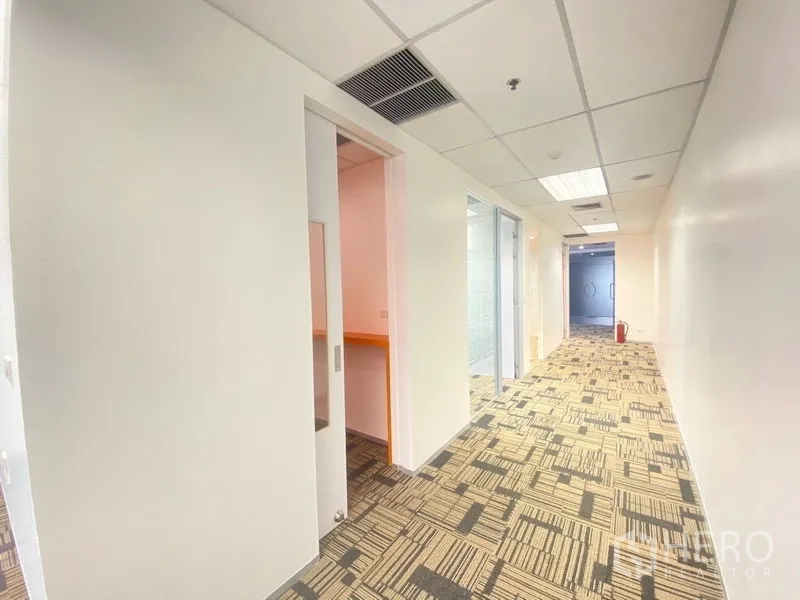 Office Space for rent in Chatuchak, Bangkok - Bright corridor with sliding door, carpet tiles, and glass-partitioned rooms in a modern office.