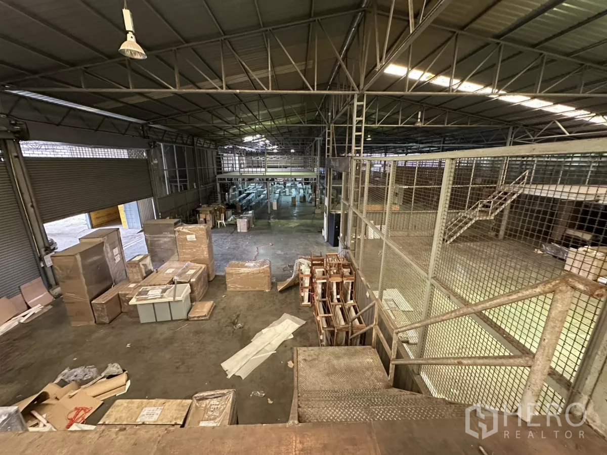 Warehouse for rent in Yan Nawa, Bangkok - Elevated view of warehouse floor with crates, pallets and a roller door.