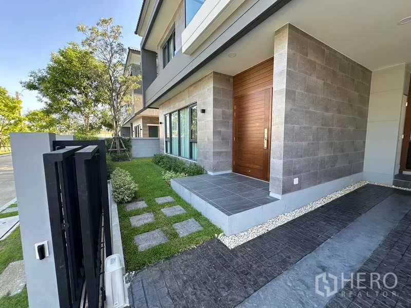 Detached House for rent in Bang Phli, Samut Prakan - Front porch with wooden entrance door, stone cladding and small lawn.