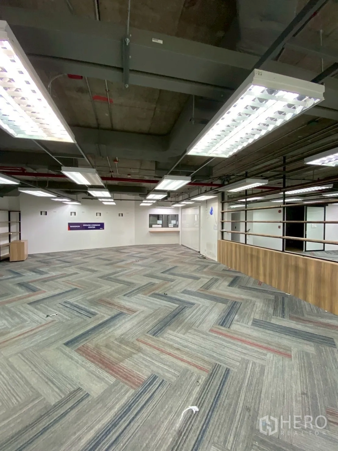 Office Space for rent in Watthana, Bangkok - Wide open office area with suspended lighting and wood-fronted counter.