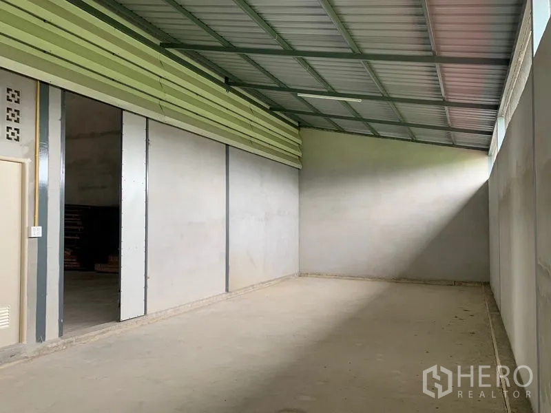 Warehouse for rent or sale in Sai Noi, Nonthaburi - Long storage bay with sliding partition walls, metal roof, and a natural light strip.