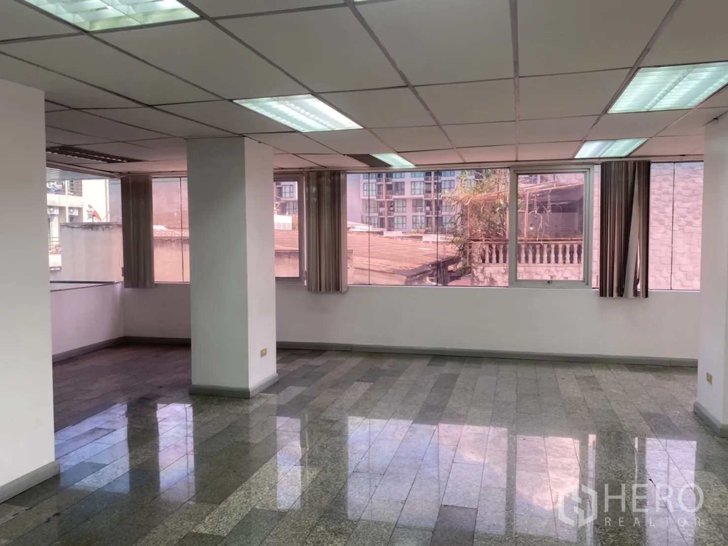 Office Space for rent in Khlong Toei, Bangkok - Corner office zone featuring wraparound windows with vertical blinds and glossy stone flooring.
