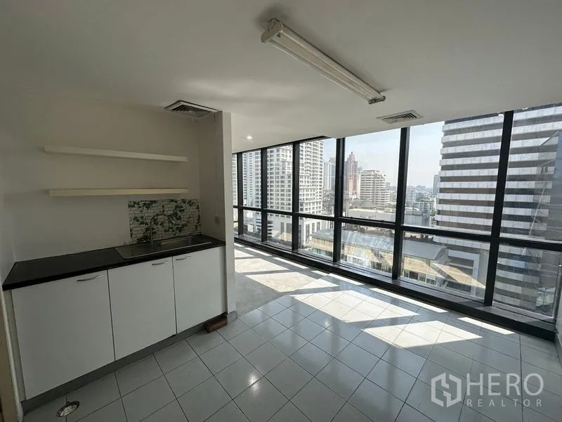 Office Space for rent in Khlong Toei, Bangkok - Pantry with sink and cabinets beside full-height glass windows overlooking the city.