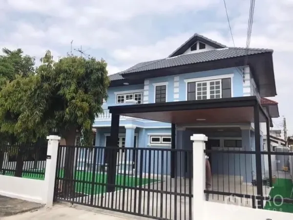 Detached House for rent in Nonthaburi - Two-storey blue detached house with gated fence and a covered carport.