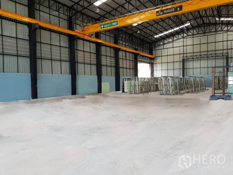货栈 出租在Mueang Pathum Thani, Pathum Thani - 仓库内部高挑钢结构，设行车吊与平整混凝土地面，适合存储与生产