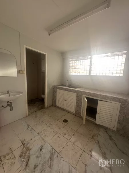Shophouse for rent in Khlong Toei, Bangkok - Rooftop terrace with patterned privacy walls and distant city buildings.