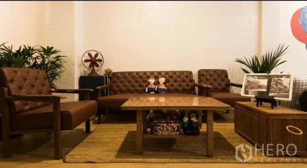 Townhouse for rent in Khlong Toei, Bangkok - Cozy sitting area with vintage leather sofas, coffee table and indoor plants.
