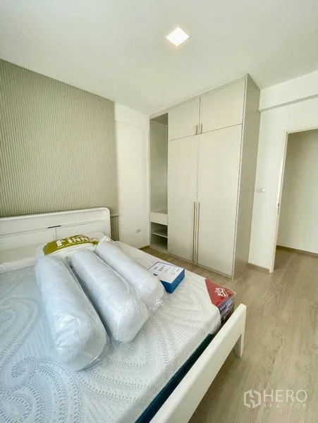 Townhouse for rent or sale in Prawet, Bangkok - Guest bedroom with built‑in wardrobe and light wood flooring.