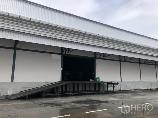 Warehouse for rent in Bang Phli, Samut Prakan - Metal-clad warehouse exterior with a covered loading dock and ramp for truck access in Samut Prakan.