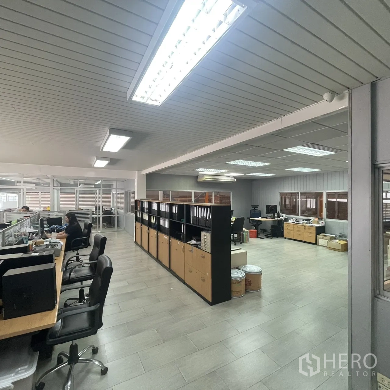 Factory for rent in Khlong Toei, Bangkok - Open-plan office with desks, shelving, and tiled floors for team operations.
