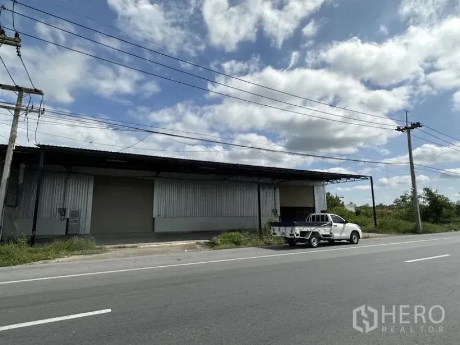 货栈 出租在Khlong Luang, Pathum Thani - 巴吞他尼府空銮县临路仓库外立面，金属墙板，装卸区与皮卡车。