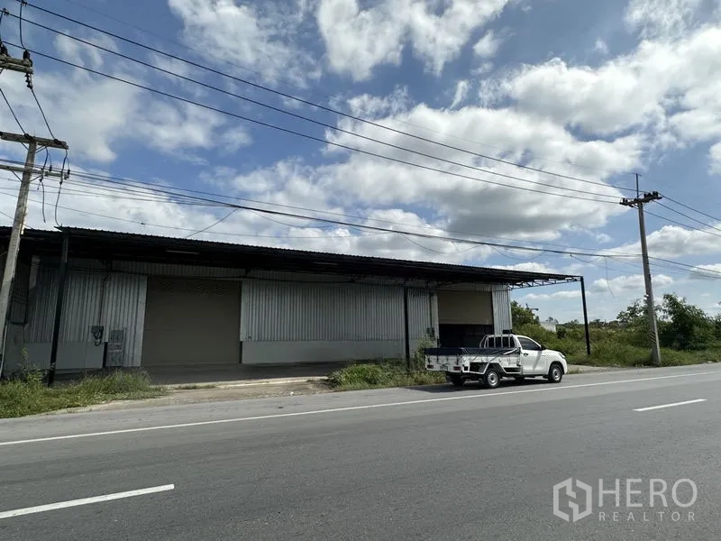 Warehouse for rent in Khlong Luang, Pathum Thani - Roadside warehouse facade with metal cladding, loading bay and pickup truck in Khlong Luang, Pathum Thani.