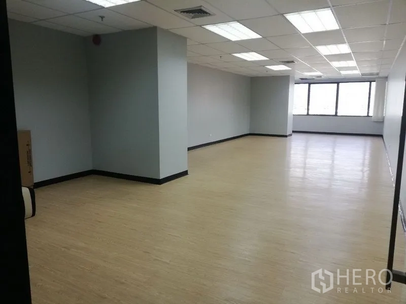 Office Space for rent in Watthana, Bangkok - Spacious open office area with columns, ceiling lights, and wide windows.