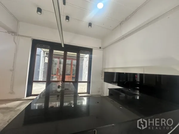 Home Office for rent in Pathum Wan, Bangkok - Counter and display area facing full-height glazing with wooden-framed doors.