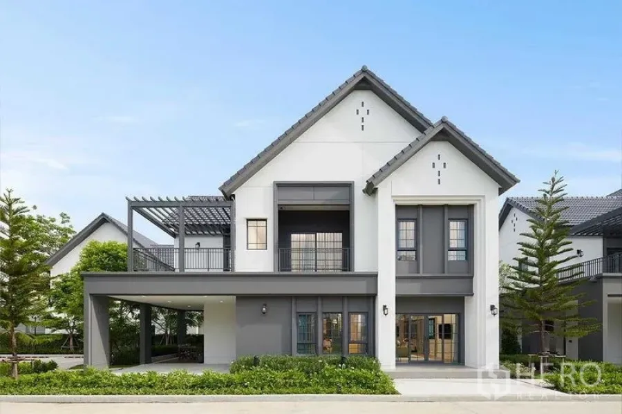 Detached House for sale in Bang Phli, Samut Prakan - Contemporary two-storey detached house with gabled roof, balcony, covered carport and landscaped frontage.