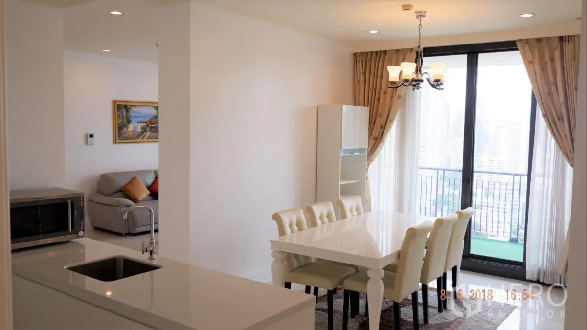 Condominium for rent in Khlong Toei, Bangkok - Dining area by sliding doors to the balcony, viewed from the kitchen counter.