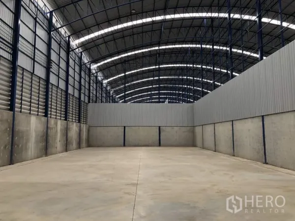 Factory for rent in Lat Lum Kaeo, Pathum Thani - Large open-span warehouse floor with arched roof and ventilated side walls.