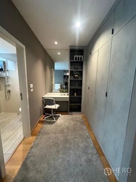Townhouse for sale in Saphan Sung, Bangkok - Hallway dressing area with built‑in wardrobes, open shelving and a compact work desk under recessed lights.