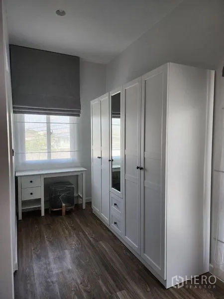 Detached House for rent in Bang Kapi, Bangkok - Dressing room with white wardrobes and a small desk by the window.