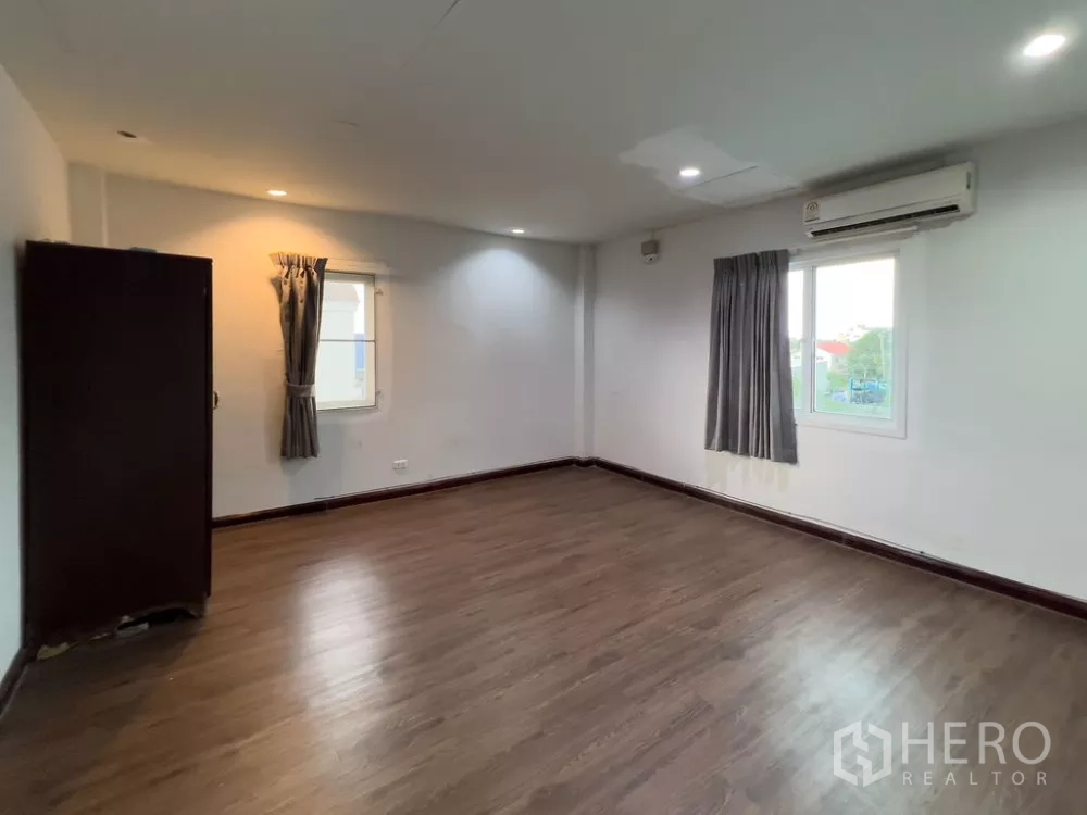 Home Office for rent in Lat Phrao, Bangkok - Spacious upper-level room with wood flooring, windows and air-conditioning.