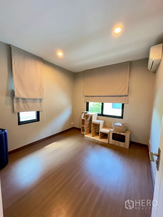 Detached House for rent in Samut Prakan - Versatile spare room with windows, blinds and wood floors.