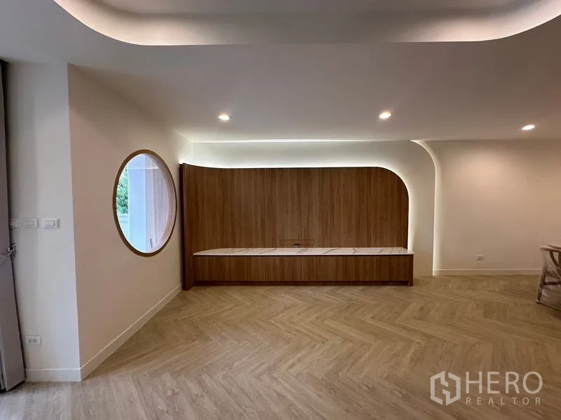 Home Office for rent in Khlong Toei, Bangkok - Feature wall with curved wood paneling, circular window and recessed lighting.